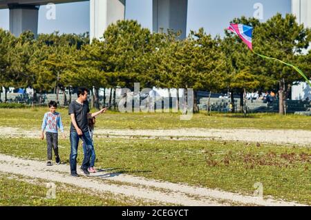 Osaka / Japan - 28. April 2018: Vater mit Sohn und Tochter, Drachen im Park fliegen Stockfoto