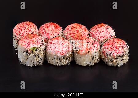 Traditionelle köstliche frisch gebackene Yaki Roll auf schwarzem Hintergrund mit Reflexion gesetzt. Sushi-Rolle mit Reis, Frischkäse, Avocado, Lachs. Kalifornien Stockfoto