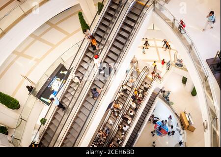 Blick auf die Rolltreppen und die unteren Etagen des riesigen Einkaufszentrums oder Einkaufszentrum Siam Paragon in Bangkok Thailand. Stockfoto