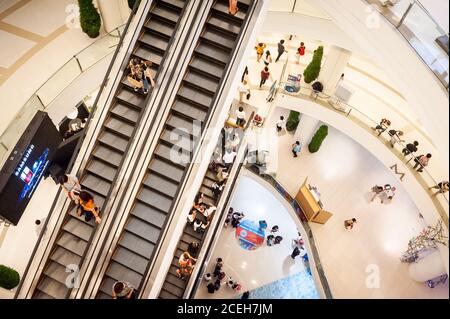 Blick auf die Rolltreppen und die unteren Etagen des riesigen Einkaufszentrums oder Einkaufszentrum Siam Paragon in Bangkok Thailand. Stockfoto