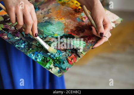Künstler Pinsel und Ölfarben auf Holzpalette. Makro Künstler Palette, Textur gemischt Ölfarben in verschiedenen Farben und Sättigung. Palette mit pa Stockfoto