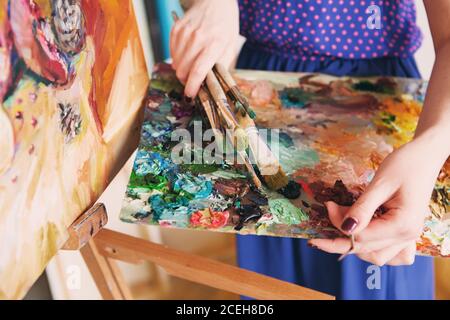 Künstler Pinsel und Ölfarben auf Holzpalette. Makro Künstler Palette, Textur gemischt Ölfarben in verschiedenen Farben und Sättigung. Palette mit pa Stockfoto