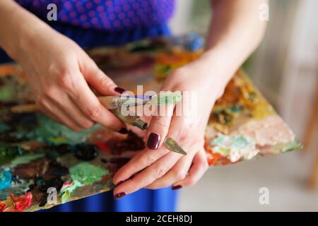 Künstler Pinsel und Ölfarben auf Holzpalette. Makro Künstler Palette, Textur gemischt Ölfarben in verschiedenen Farben und Sättigung. Palette mit pa Stockfoto