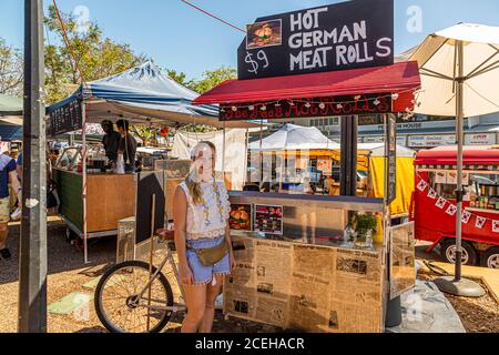 Junger deutscher Unternehmer in Australien, der heiße deutsche Fleischbrötchen verkauft Stockfoto