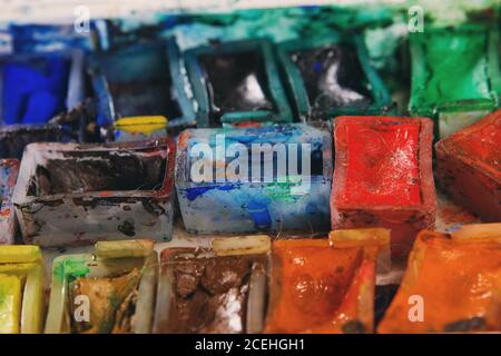 Künstler Pinsel und Aquarellfarben auf Palette. Vintage stilisierte Foto von Pinsel Nahaufnahme und Künstler Palette. Verwendete Palette mit Pinsel Stockfoto