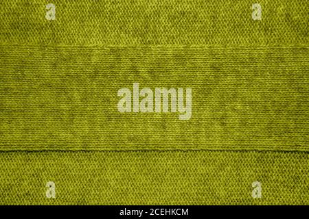 Wolle Pullover Textur Nahaufnahme. Gestrickter Jersey-Hintergrund mit Reliefmuster. Zöpfe im Maschinenstrickmuster Stockfoto