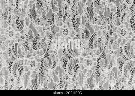 Weiße durchbrochene Spitze Hintergrund Textur. Weißer Guipure-Stoff mit Ornament. Zarte Spitze mit floralem Muster Stockfoto