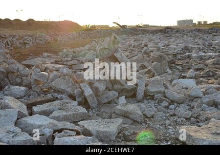 Zerbrochene Asphaltstücke auf einer Baustelle. Recycling und Wiederverwendung zerkleinerten Betonschutt, Asphalt, Baumaterial, Blöcke. Zerkleinert сoncrete Bac Stockfoto