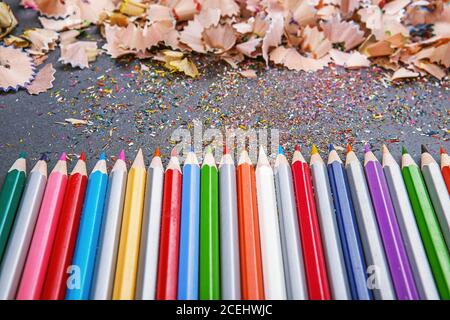 Nahaufnahme von farbigen Bleistift-Buntstifte und Bleistift-Buntstifte Späne auf dunklem Hintergrund. Geschärfte Buntstifte Stockfoto