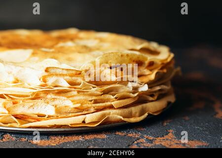 Russische Pfannkuchen vor dunklem Hintergrund. Pancake Week - das alte slawische Fest des Sehens aus dem Winter, von dem die Brauch der Backpfanne Stockfoto