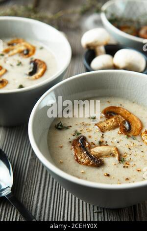 Zwei Schüsseln mit köstlicher Pilzsuppe auf Holztisch. Food-Fotografie Stockfoto