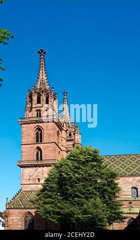 Basler Münster; roter Sandstein, kunstvoller Turm; Kirchturm; bunt gefliestes Dach; Sonnenuhr, mittelalterlicher Dom; alt; evangelische Kirche; religiöses Gebäude; spät Stockfoto