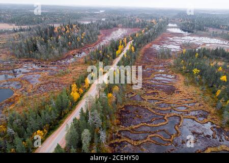 Eine Luftaufnahme einer Straße durch eine einzigartige Aapa Mires in Nordfinnland während Herbstlaub. Stockfoto