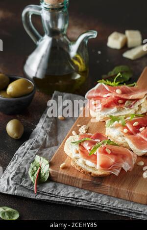 Traditioneller parma-Schinken Antipasto. Bruschetta Set mit Parmaschinken und Parmesankäse. Kleine Sandwiches mit Prosciutto, Parmesankäse, frischem aru Stockfoto