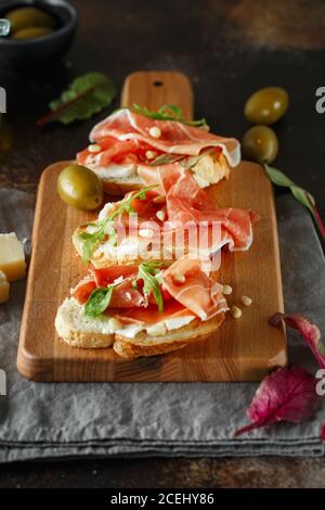 Traditioneller parma-Schinken Antipasto. Bruschetta Set mit Parmaschinken und Parmesankäse. Kleine Sandwiches mit Prosciutto, Parmesankäse, frischem aru Stockfoto
