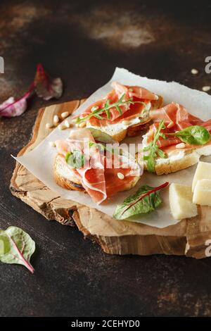 Traditioneller parma-Schinken Antipasto. Bruschetta Set mit Parmaschinken und Parmesankäse. Kleine Sandwiches mit Prosciutto, Parmesankäse, frischem aru Stockfoto