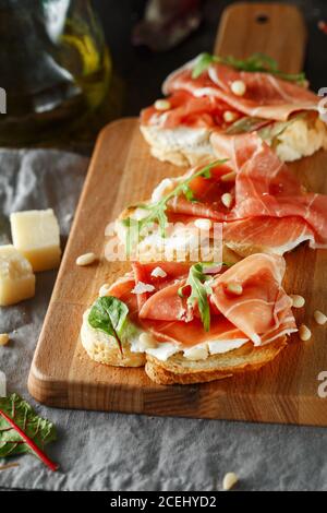 Traditioneller parma-Schinken Antipasto. Bruschetta Set mit Parmaschinken und Parmesankäse. Kleine Sandwiches mit Prosciutto, Parmesankäse, frischem aru Stockfoto