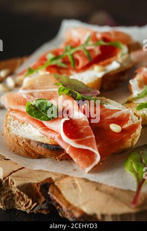 Traditioneller parma-Schinken Antipasto. Bruschetta Set mit Parmaschinken und Parmesankäse. Kleine Sandwiches mit Prosciutto, Parmesankäse, frischem aru Stockfoto