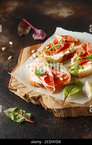 Traditioneller parma-Schinken Antipasto. Bruschetta Set mit Parmaschinken und Parmesankäse. Kleine Sandwiches mit Prosciutto, Parmesankäse, frischem aru Stockfoto