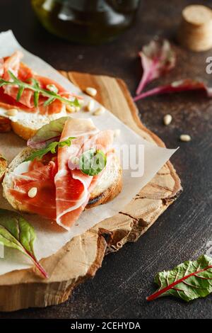 Traditioneller parma-Schinken Antipasto. Bruschetta Set mit Parmaschinken und Parmesankäse. Kleine Sandwiches mit Prosciutto, Parmesankäse, frischem aru Stockfoto
