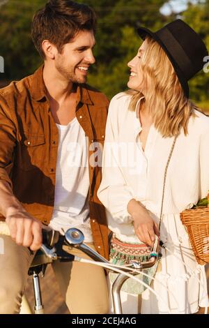 Bild von jungen kaukasischen Paar lächeln und Fahrrad fahren in Auf dem Land Stockfoto