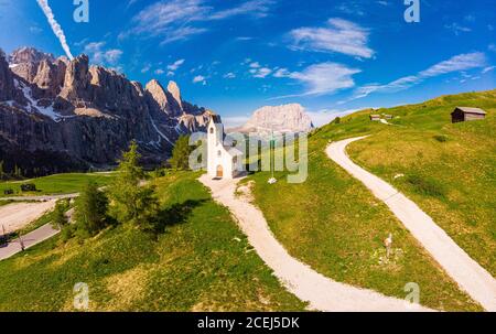 Schöne Luftpanorama zu Pfad zu kleinen weißen Kapelle San Maurizio und Dolomiti Berglandschaft im Hintergrund. Wolkenstein in Gröden Stockfoto