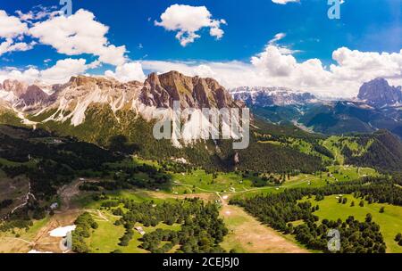 Luftaufnahme von der Drohne zum Col Raiser Plateau im sonnigen Sommertag. Landschaft des zerklüfteten Sella Mountain mit grünem Tal auf grasbewachsenen Hügel Dorf St Stockfoto