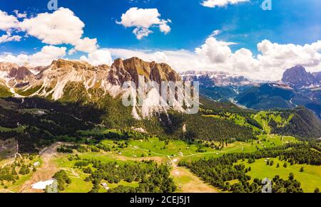 Luftaufnahme von der Drohne zum Col Raiser Plateau im sonnigen Sommertag. Landschaft des zerklüfteten Sella Mountain mit grünem Tal auf grasbewachsenen Hügel Dorf St Stockfoto