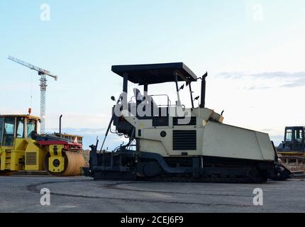 Asphaltfertiger Maschine und Straßenwalze arbeiten auf der Baustelle während Asphalt Straßenreparatur. Pflasterwalzenmaschine auf Pflasterarbeiten. Stockfoto