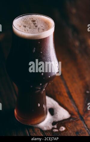 Stout Bier im Glas auf dunklem Hintergrund Stockfoto