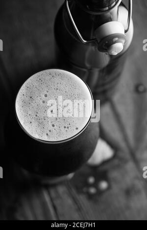 Stout Bier in Glas abd Flasche auf dunklem Hintergrund Stockfoto