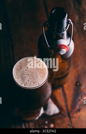 Stout Bier in Glas abd Flasche auf dunklem Hintergrund Stockfoto