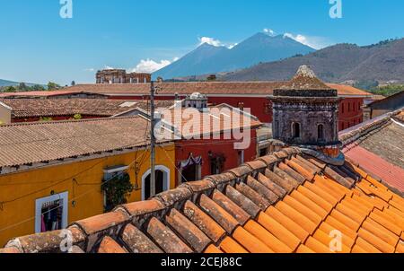 Die Skyline von Antigua von einem Dach aus mit vulkanischen Aktivitäten und Ausbrüchen des Fuego Vulkans, Guatemala. Stockfoto