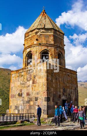 Georgien Gergeti 15 september 2018: Touristen besuchen die Kirche der Heiligen Dreifaltigkeit. Kirche der Heiligen Dreifaltigkeit in der Nähe des Dorfes Stepantsminda in Georgien Stockfoto