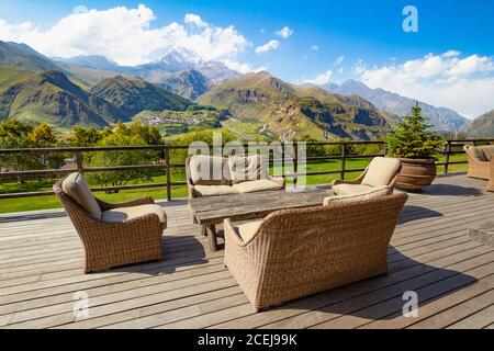 Schöne Aussicht von der Terrasse Café mit Blick auf den hohen Gipfel Kasbek, Kaukasus Berge und Gergeti Trinity Church Tsminda Sameba, Heilig Stockfoto