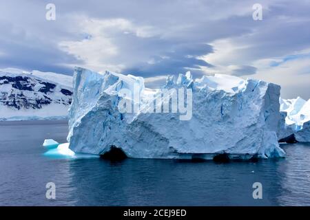 Ein blauer Eisberg, der in Admiralty Bay, Antarktis, vorbeischwimmt. Stockfoto