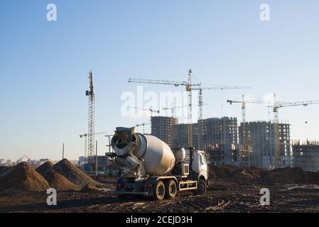 Schwere Mischer Betonwagen wartet auf Beton auf einer Baustelle geladen werden. Turmdrehkrane bauen ein neues Wohngebäude. Stockfoto