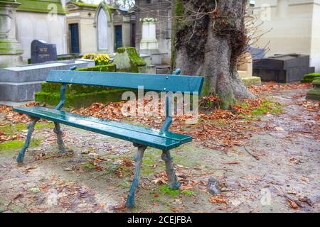 Regnerischer Tag auf dem Friedhof . Leere Bank im Friedhof Stockfoto