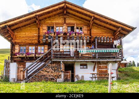 Am Haupthaus der Pöris Alp hängt eine Sammlung riesiger Kuhglocken. Von hier aus bekommt der Lenkerhof seinen frischen Ziegenkäse. Alp Dairy, Lenk, Schweiz, Lenk, Schweiz Stockfoto