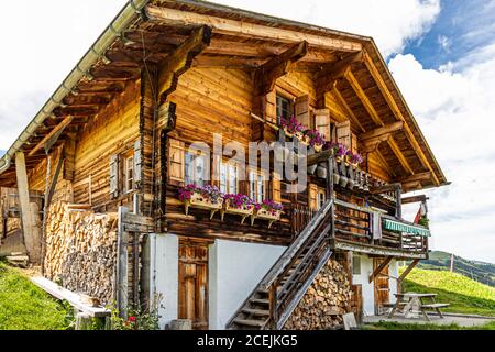 Am Haupthaus der Pöris Alp hängt eine Sammlung riesiger Kuhglocken. Von hier aus bekommt der Lenkerhof seinen frischen Ziegenkäse. Alp Dairy, Lenk, Schweiz, Lenk, Schweiz Stockfoto