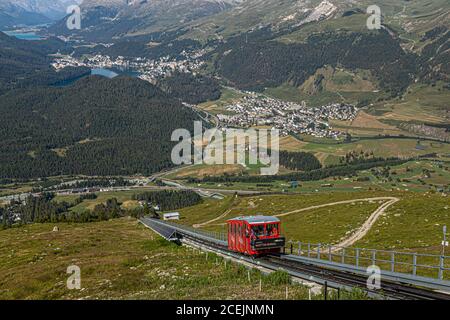 Die Muottas-Muragl-Seilbahn führt durch die Landschaft von Graubünden, Schweiz, mit Blick auf St. Moritz und die Engadiner Seen im Tal. Stockfoto
