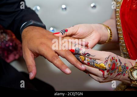 Eine Braut trägt einen Ring am Finger des Bräutigams. Indische Hochzeit. Stockfoto