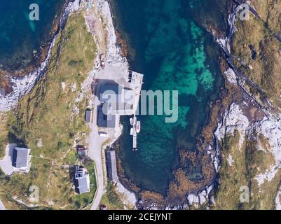 Drohnenansicht der Küste der Lofoten Insel mit Ferienhaus und Pier auf blauem transparentem Wasser, Norwegen Stockfoto