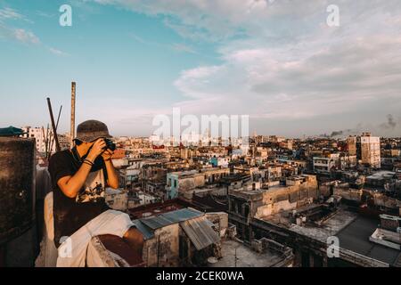 LA HABANA, KUBA - 1. MAI 2018: Mann, der mit einer Fotokamera Fotos vom alten armen Viertel der kubanischen Stadt im Sonnenlicht macht. Stockfoto