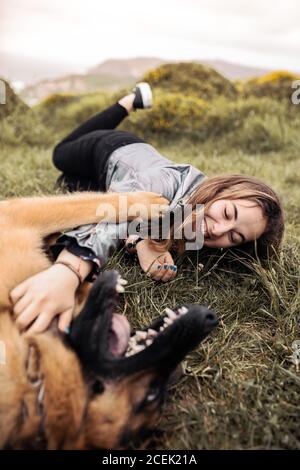 Junge Frau streicheln Hund in der Natur Stockfoto