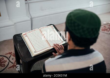 Istanbul, Türkei - August, 20 2018: Rückansicht des religiösen Mannes, der sitzt und den Koran liest Stockfoto