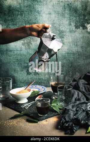 Frau, die Kaffee in Kristallglas serviert Stockfoto