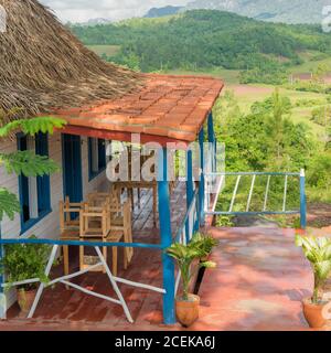 Buntes rustikales Holzhaus mit einer Veranda mit Blick auf die Vinales Tal in Kuba Stockfoto