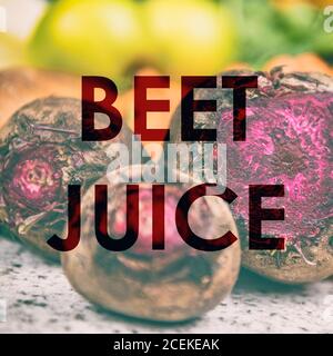 RÜBENSAFT Wörter auf Foto Hintergrund von frischen roten Rüben in der Küche oder Bauernmarkt geschrieben. RAW Bio Entsaften Trend der Gemüsegetränk für Gewicht Stockfoto