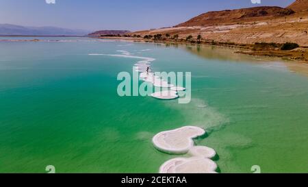 Liebevolles Paar ruht auf dem toten Meer. Salzküsten, das Meer in Israel stirbt aus und trocknet aus Stockfoto